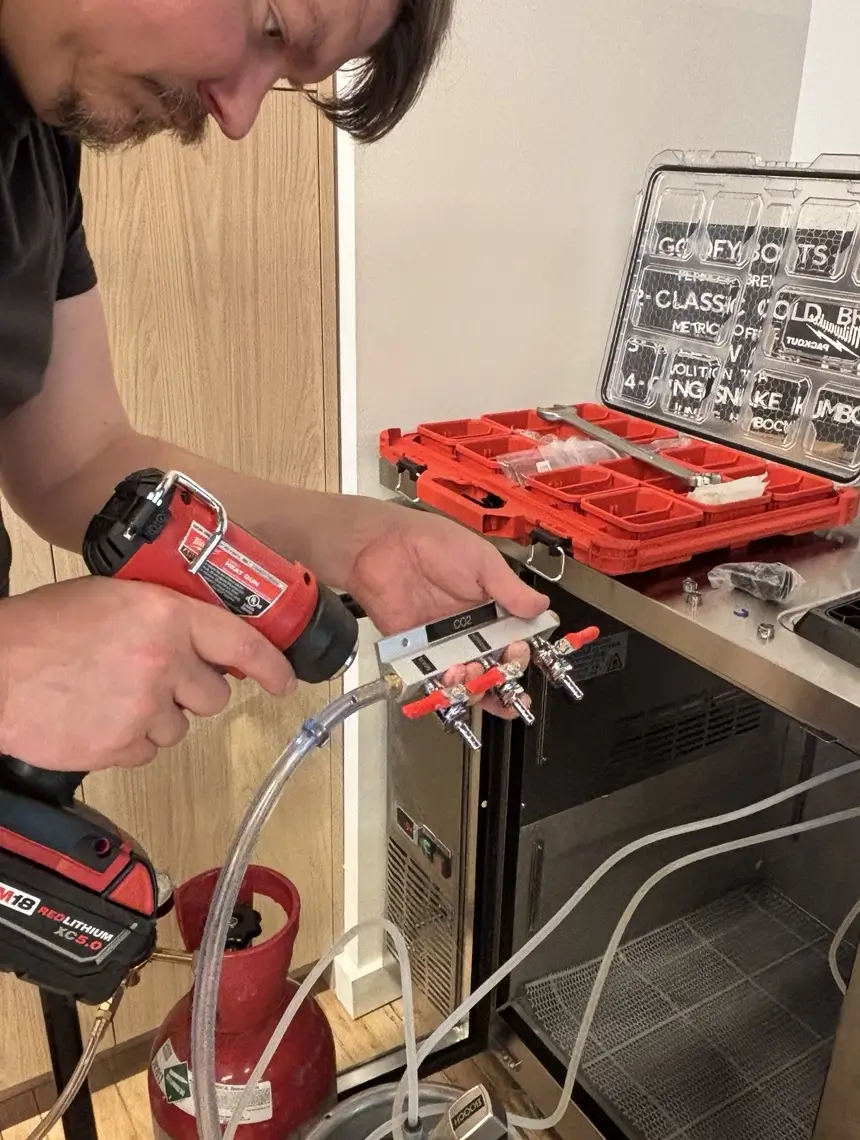 Technician performing maintenance on a commercial draft beer system